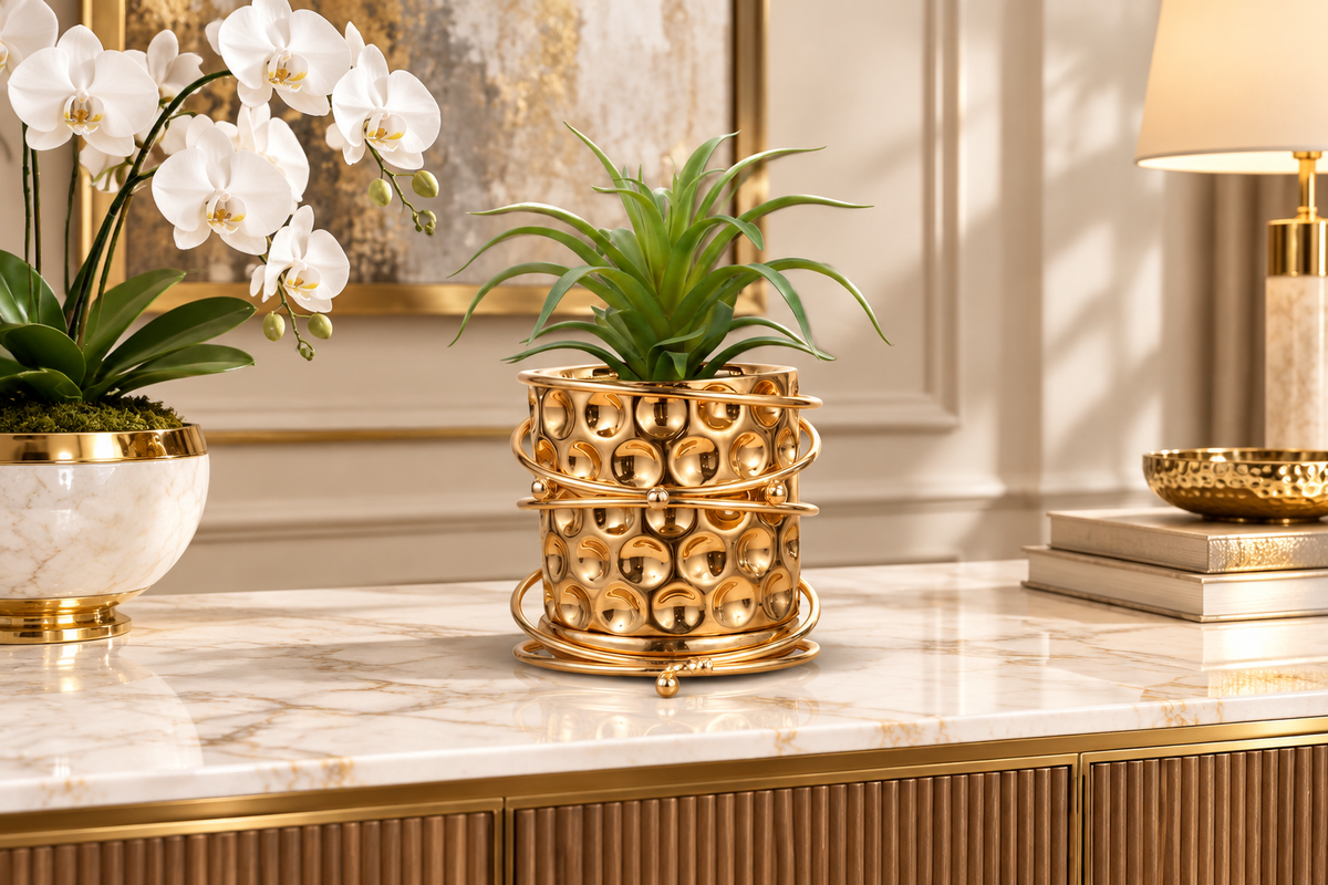 Gold planter with orchid on marble console