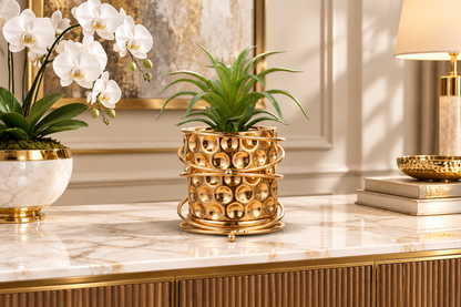 Gold planter with orchid on marble console